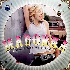 Album cover for Madonna's single 'What It Feels Like for a Girl', featuring a photo of a woman in a sleeveless top and belt, standing next to a classic car.