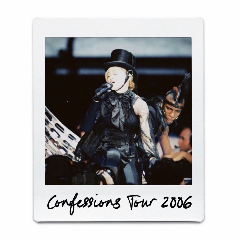 Image of a performer wearing a black outfit and top hat, singing on stage during the Confessions Tour in 2006.