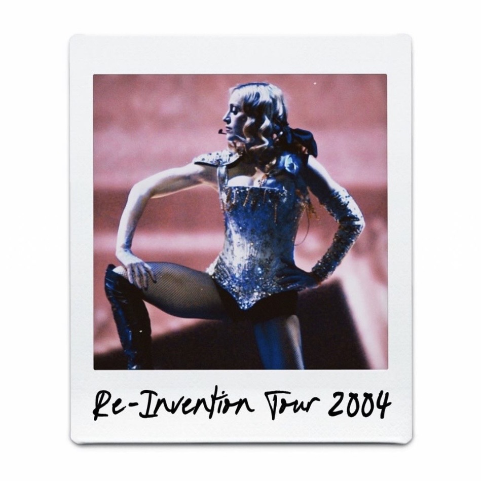 A performer striking a dynamic pose on stage, wearing a sparkling costume during the Re-Invention Tour in 2004.
