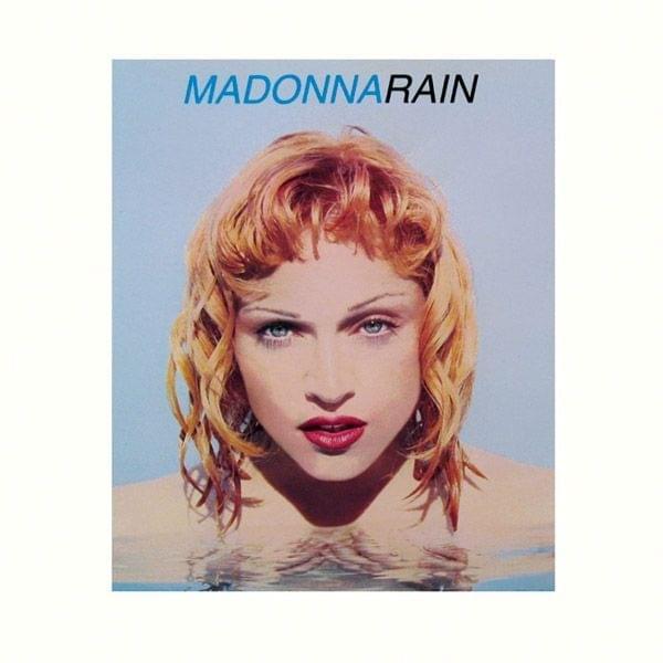 Cover image of Madonna's single 'Rain', featuring a close-up of her face with wet, shoulder-length blonde hair against a light blue background.