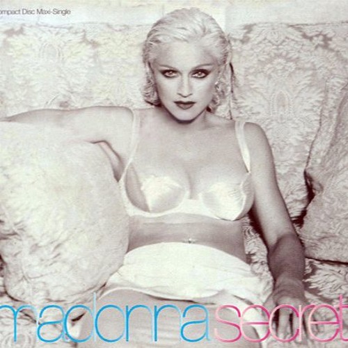 Black and white image of a woman with platinum blonde hair wearing a white lingerie set, seated on a couch with a patterned background. The text 'Madonna Secret' appears in pink and blue at the bottom.