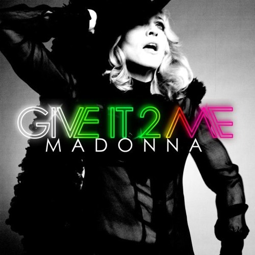 Album cover for 'Give It 2 Me' by Madonna featuring a black and white image of the artist in a dramatic pose, with colorful text overlay.
