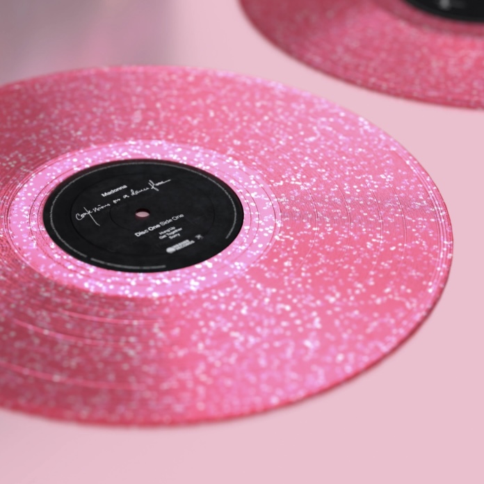 Close-up of a pink vinyl record with glitter, featuring a black label in the center.