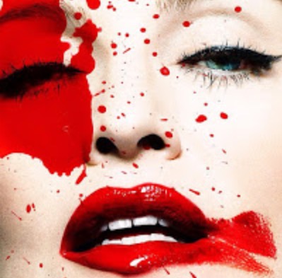 Close-up of a woman's face with bold red lipstick and artistic red paint splashes, creating a dramatic and striking visual effect.