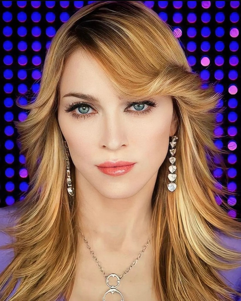 A close-up portrait of a woman with long, blonde hair and striking blue eyes. She is wearing silver heart-shaped earrings and a matching necklace. The background features purple and blue dots, creating a vibrant atmosphere.