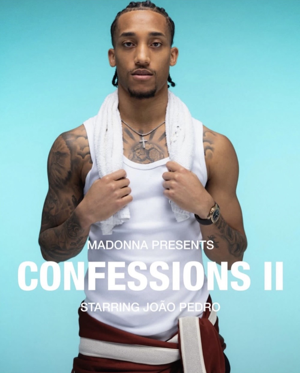 A young man with braided hair is standing in front of a light blue background, wearing a white tank top and a towel around his neck, promoting 'Confessions II' starring João Pedro.